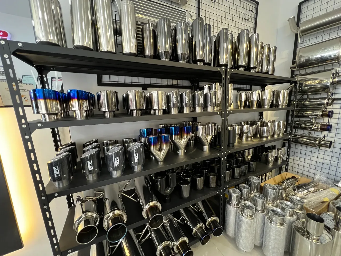 Shelves of exhaust tips in different brands, sizes and finishes at the Nitrofuze shop